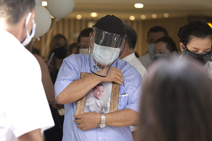 Hernando Enrique Rangel abraza la foto de uno de sus nietos después de la eucaristía.