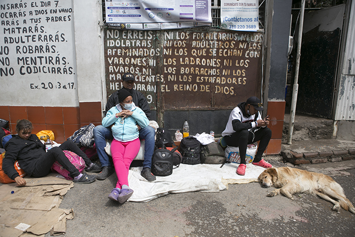 Venezolanos descansan frente a uno de los albergues que les presta atención humanitaria.