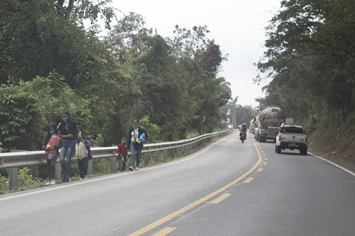 Dos madres caminan con sus pequeños hijos sobre la vía Cúcuta - Pamplona.