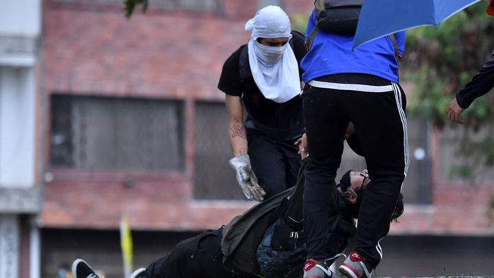 Un hombre ayudado por compañeros manifestantes luego de ser alcanzado por una bala durante enfrentamientos con la Policía. / Foto: AFP