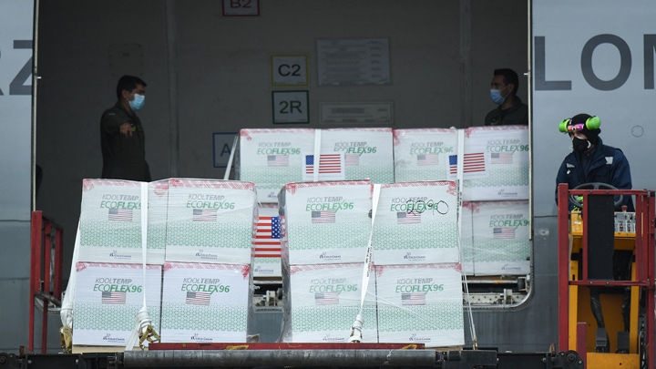 Miembros de la Fuerza Aérea Colombiana descargan 2.5 millones de dosis de la vacuna COVID-19 Janssen donada por Estados Unidos, en el Aeropuerto Internacional El Dorado. / Foto: AFP