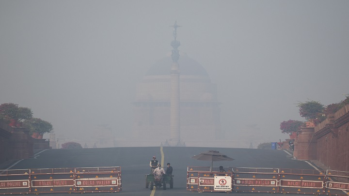 La gente tiene que caminar en medio de condiciones de niebla tóxica en Nueva Delhi el 20 de noviembre de 2021./AFP