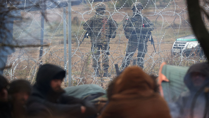 Militares polacos detrás de una cerca de alambre de púas en la frontera entre Bielorrusia y Polonia