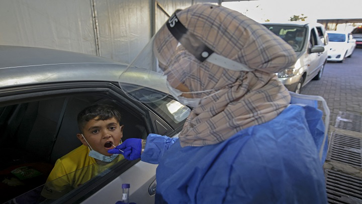 Un médico recolecta una muestra de hisopo de un niño en un sitio de pruebas de conducción de Covid-19 en Jerusalén,/AFP