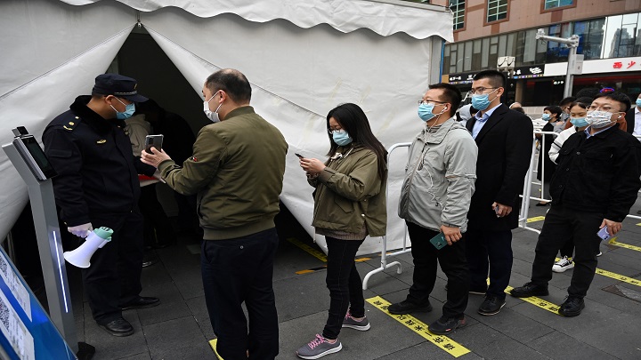 Personas hacen fila para recibir una inyección de refuerzo de la vacuna contra la Covid-19 en una tienda de campaña instalada fuera de un centro comercial en Beijing (China)./AFP