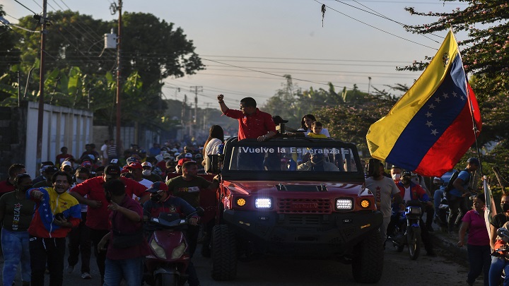 Arreaza, en un vehículo todo terreno tipo militar, sin techo, con un rótulo en el parabrisas que lee: "¡Vuelve la esperanza!"./AFP