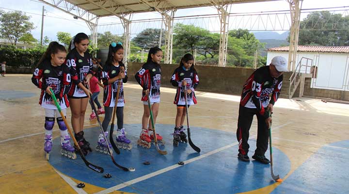 El instructor de hockey en línea, el profesor Luis Ernesto Higuera en una de las prácticas con sus alumnas.