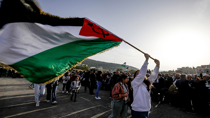 Árabe-israelíes marchan con una bandera palestina 