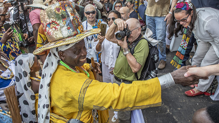 Daagbo Hounon Houna II, saluda a la multitud mientras un turista toma una fotografía durante el festival vudú en Ouidah, Benin./Foto: AFP