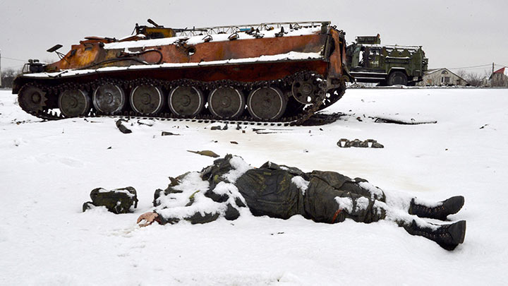 El cuerpo de un uniformado yace cerca de vehículos militares rusos destruidos al borde de la carretera en las afueras de Kharkiv, luego de la invasión rusa de Ucrania. La guerra empezó el 24 de febrero de 2022 y está generando miles de víctimas mortales, así como la mayor crisis de refugiados en el continente./Foto: AFP