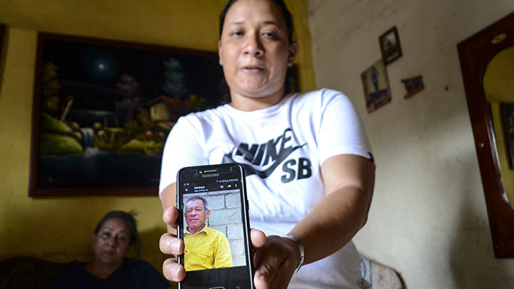 Joselyn Oropeza muestra la foto de su tío Oswaldo Oviedo, una de las nueve personas que fallecieron tras ingerir alcohol adulterado en Yaracuy, Venezuela./Foto: AFP
