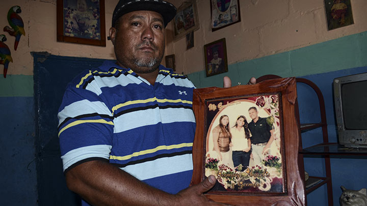 Alirio Yáñez muestra un retrato familiar de su hermano Germán Machado, una de las nueve personas fallecidas por ingerir licor adulterado./Foto: AFP