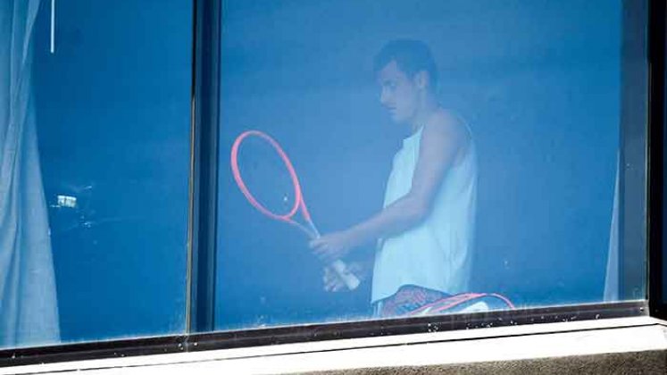 El tenista australiano Bernard Tomic se ejercita en su habitación de hotel en Melbourne el 17 de enero de 2021, mientras los jugadores se ponen en cuarentena en hoteles antes del torneo de tenis del Abierto de Australia.  Foto: AFP
