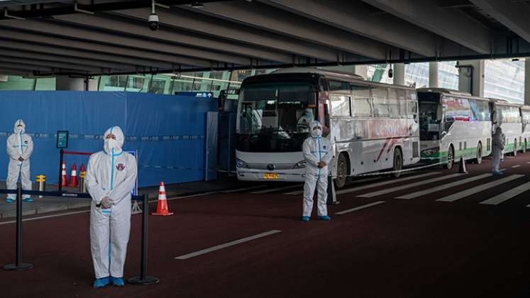 Un miembro del equipo de la Organización Mundial de la Salud (OMS) que investiga los orígenes de la pandemia Covid-19 sube a un autobús tras su llegada a una sección acordonada en el área de llegadas internacionales del aeropuerto de Wuhan/ Foto: AFP