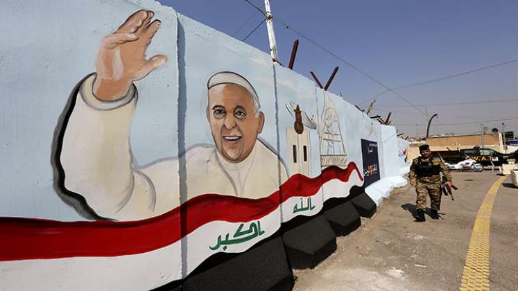  Un miembro de las fuerzas iraquíes pasa junto a un mural que representa al Papa Francisco ondeando junto a una bandera nacional iraquí dibujada en un muro de explosión fuera de la Iglesia católica siríaca de Nuestra Señora de la Liberación en el distrito Karrada de la capital de Irak.
