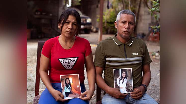 Mileidys Torrealba y Eduard José Falcón posan con retratos de su hija Eduarlis Falcón (20) quien fue asesinada en el poblado de La Misión, estado Portuguesa./ Foto: AFP