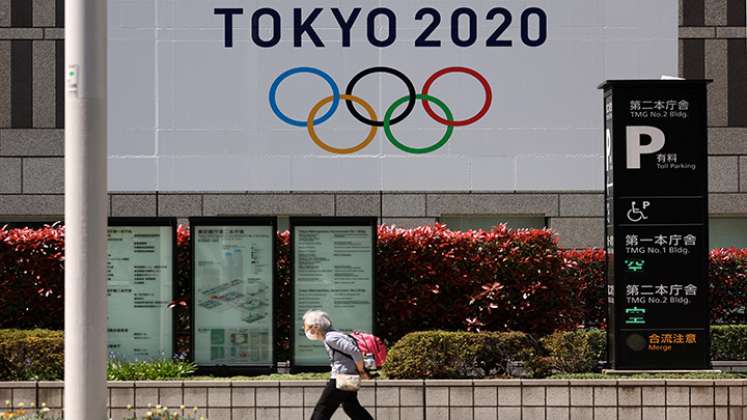 Una anciana pasa junto a una pancarta oficial de los Juegos Olímpicos de Tokio 2020 en el edificio del gobierno metropolitano de Tokio.