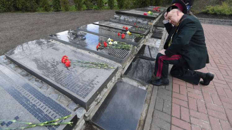 Un liquidador de la central nuclear de Chernóbil se arrodilla para presentar sus respetos en el memorial de Chernobyl en Kiev durante la conmemoración de las víctimas del desastre nuclear. / Foto: AFP 