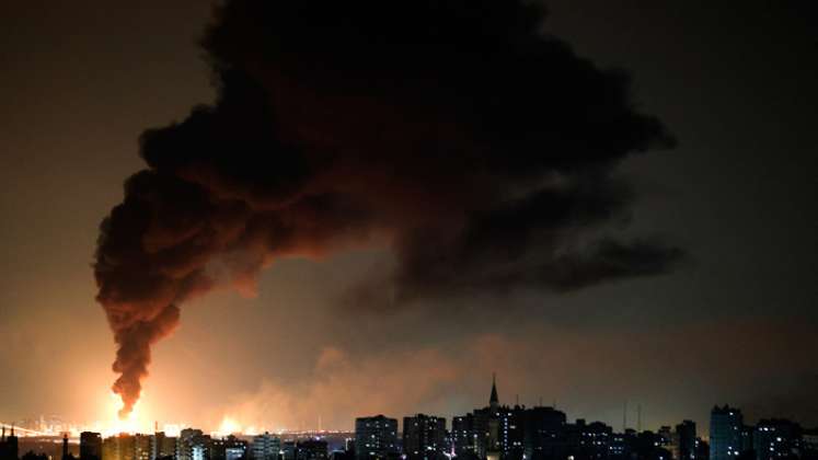 Una enorme columna de humo vista desde la ciudad de Gaza se eleva desde una instalación petrolera en la ciudad de Ashkelon, en el sur de Israel, después de que el movimiento palestino Hamas disparara cohetes desde la Franja de Gaza hacia Israel.