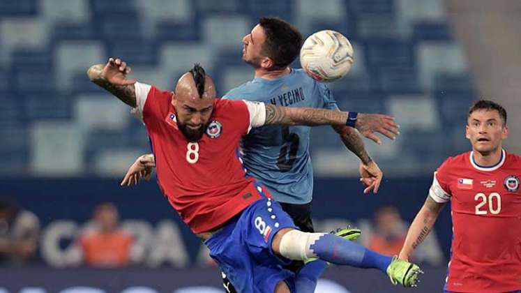 Arturo Vidal, mediocampista de Chile disputa el balón ante un defensor de Uruguay.