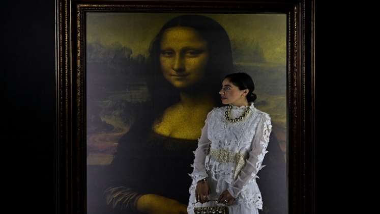  Una mujer posa para fotografías junto a una reproducción del retrato de Lisa Gherardini, esposa de Francesco del Giocondo, conocida como la Mona Lisa o La Gioconda./Foto: AFP