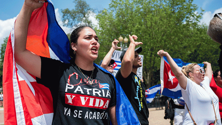 Manifestantes sostienen la bandera cubana mientras protestan frente a la Casa Blanca  En Washington contra el gobierno de la isla. / Foto AFP