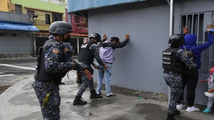 Miembros de la Policía Nacional Bolivariana requisan a personas durante enfrentamientos con presuntos integrantes de una banda criminal./Foto: AFP