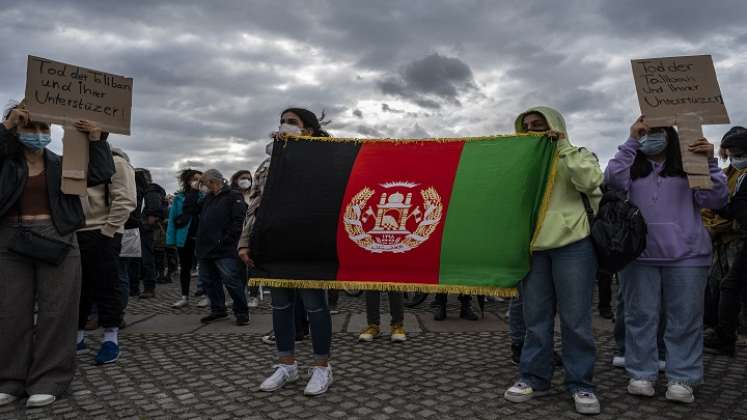 Mujeres muestran una bandera afgana mientras se manifiestan frente al edificio del Reichstag, sede de la cámara baja del parlamento Bundestag, en Berlín, para exigir un paso seguro para los afganos amenazados por los talibanes./ Foto AFP