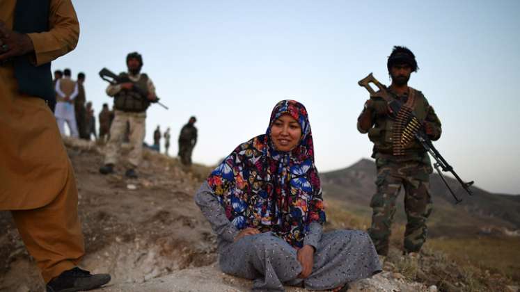 Salima Mazari (centro), una gobernadora de distrito en un Afganistán dominado por hombres, mirando desde una colina mientras está acompañada por personal de seguridad cerca de la línea del frente contra los talibanes en el distrito de Charkint en la provincia de Balkh.  / Foto: AFP