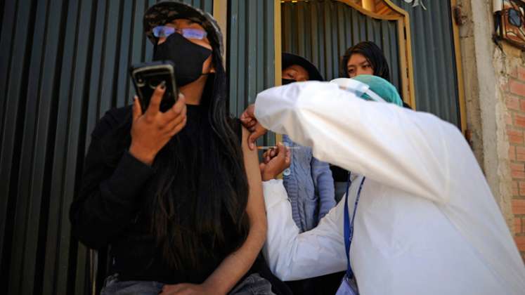 Una mujer es inoculada contra COVID-19 con la vacuna china SinoPharm por personal del Ministerio de Salud de Bolivia, afuera de su casa en el barrio Santa Rosa en El Alto, Bolivia.  / Foto: AFP