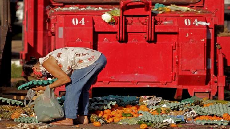 La gente recolecta frutas y verduras descartadas por los vendedores ambulantes en Belem, estado de Pará, Brasil. /AFP
